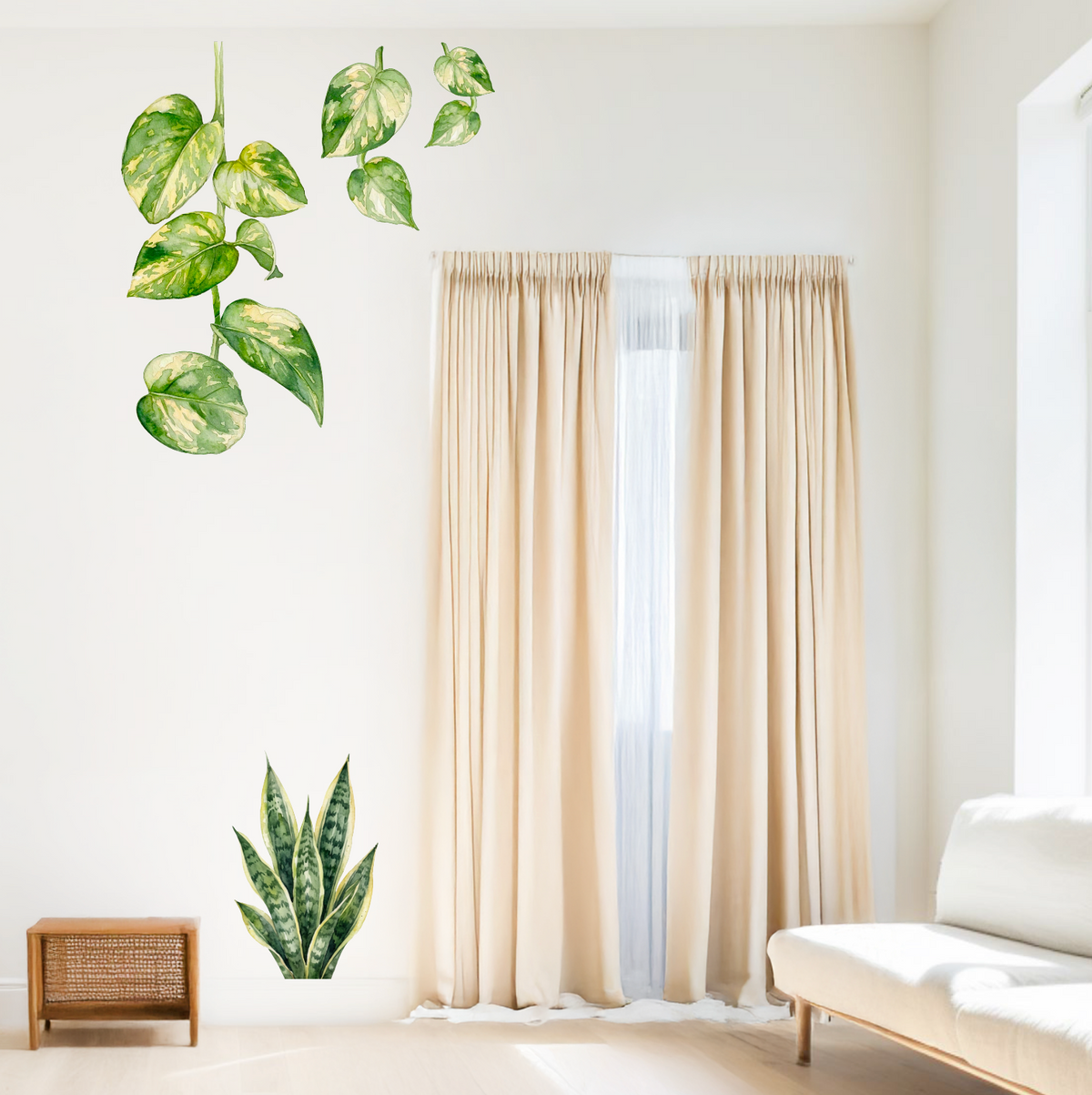 Green houseplant wall decals, including a trailing pothos plant and a snake plant, displayed on a white wall in a bright, modern living room with beige curtains and a white sofa.